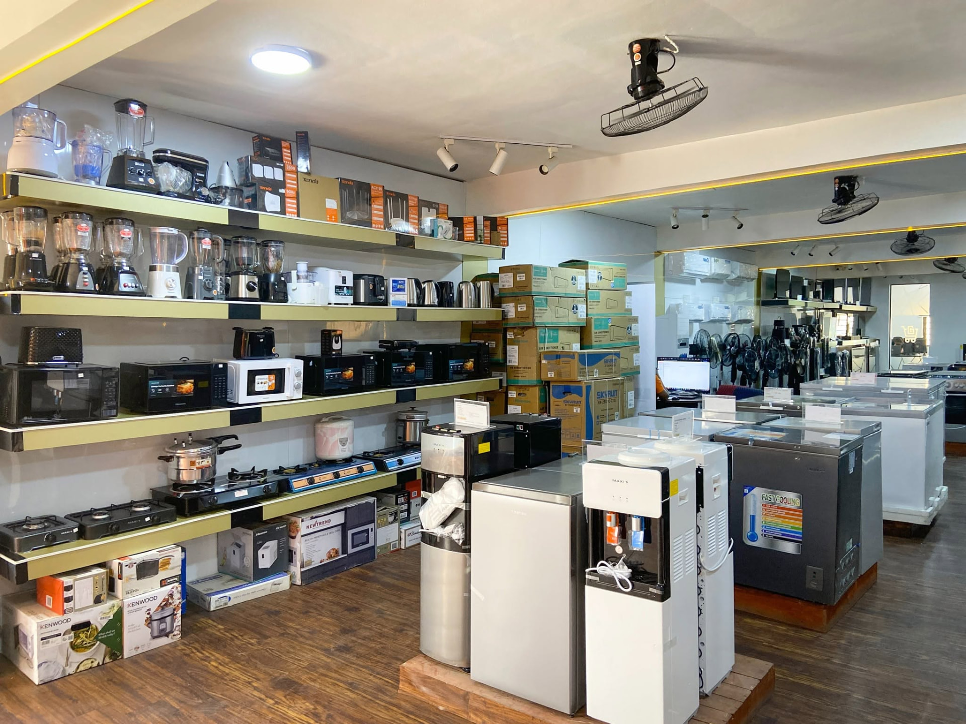 Lu Gold Store showroom shelves stocked with blenders, microwaves, freezers and air conditioners